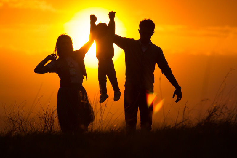 Parents and child in the sunset